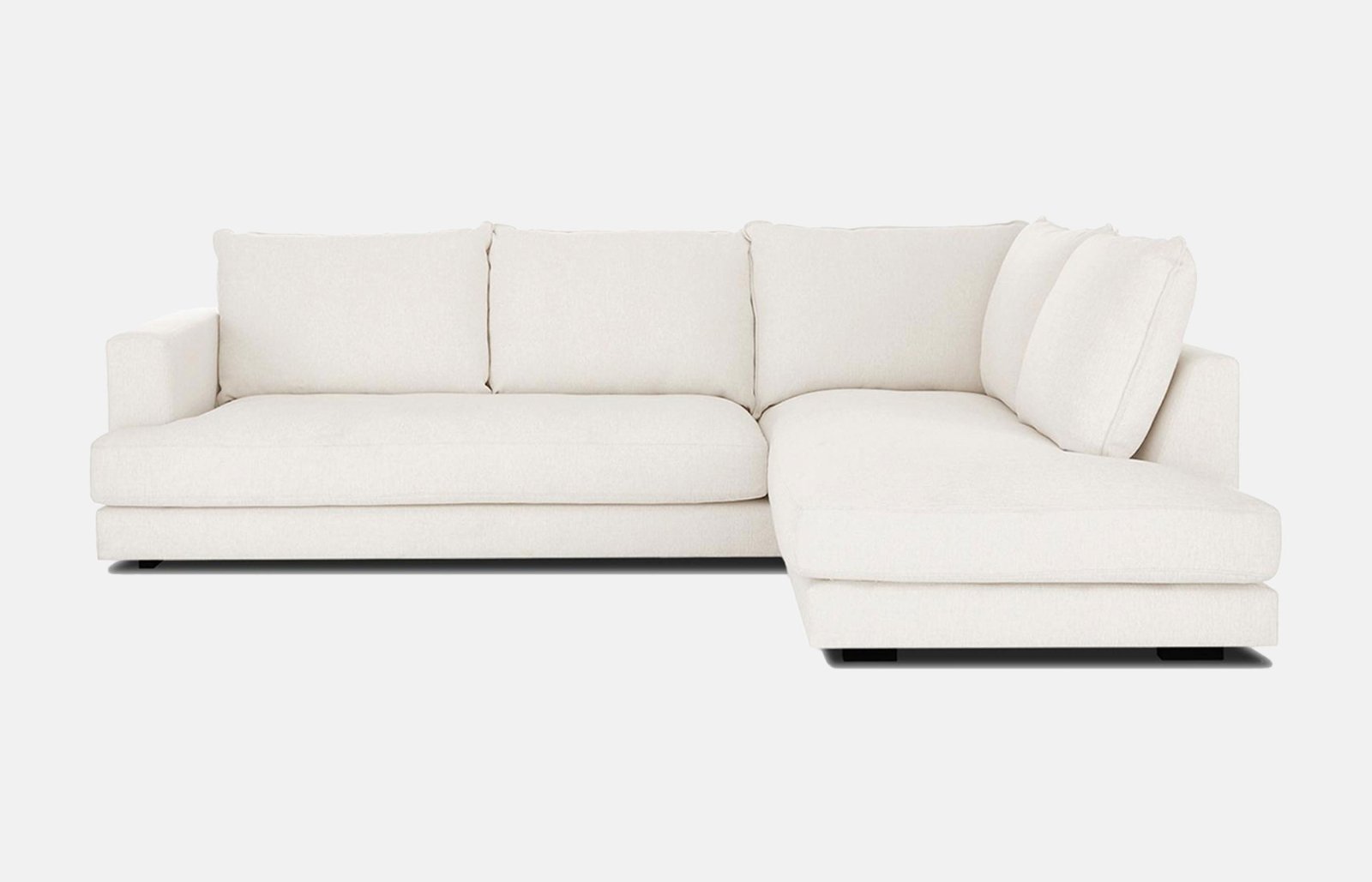 En myk og tradisjonell sofa med sjeselong, ryggputer og armlen. Den har to sitteputer og har et behagelig stoff i fargen hvit.